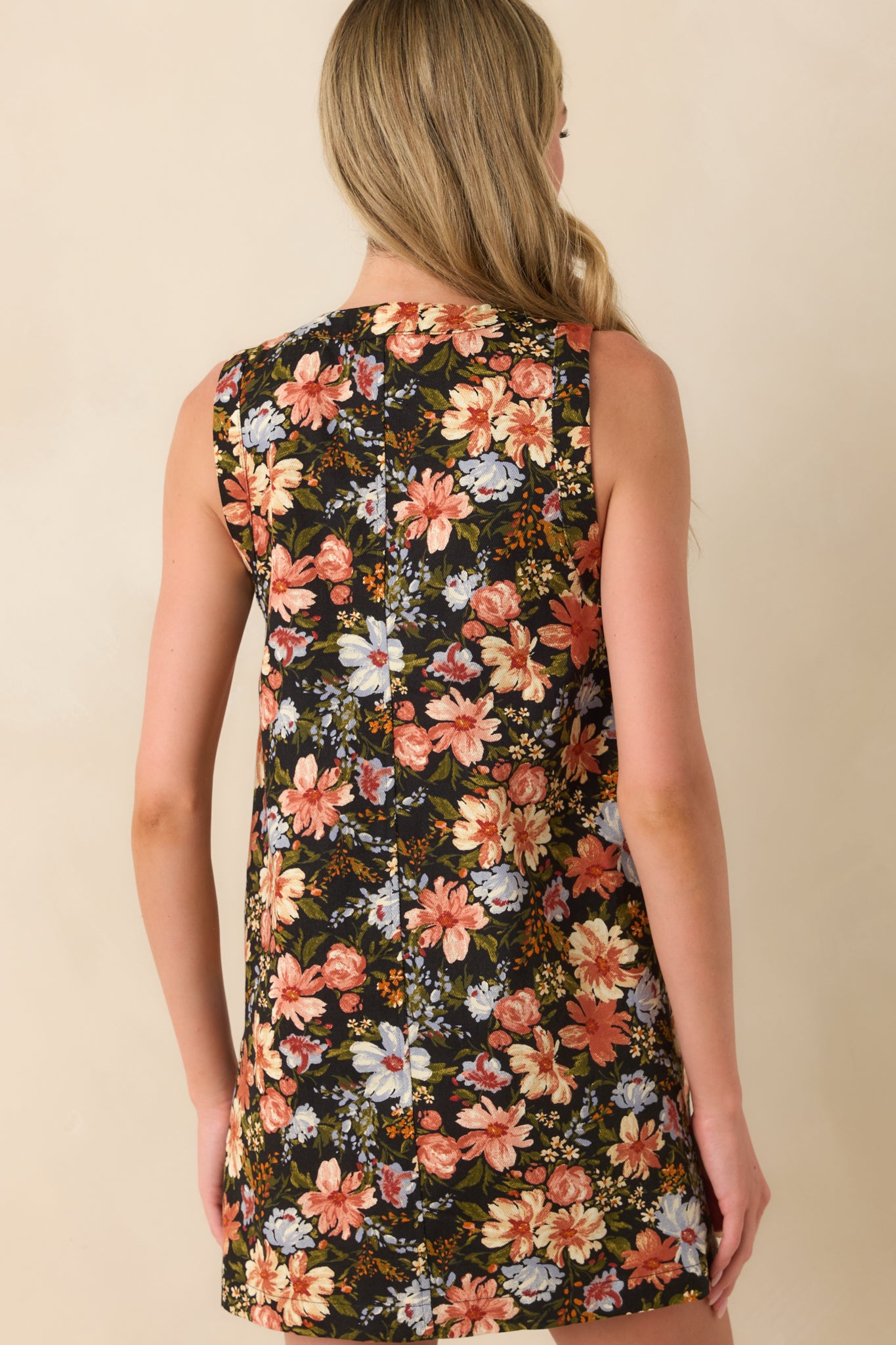 Rear view of the floral black mini dress with a sleeveless shift-style cut.