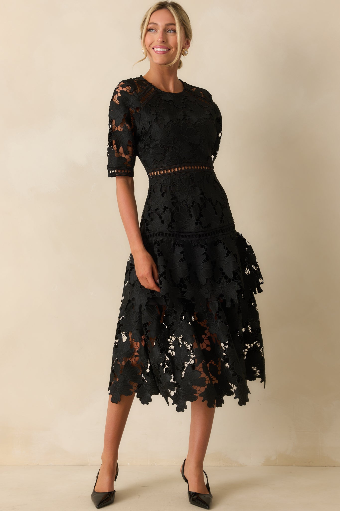 Dress in black lace overlay with v-neckline and delicate tiered construction.