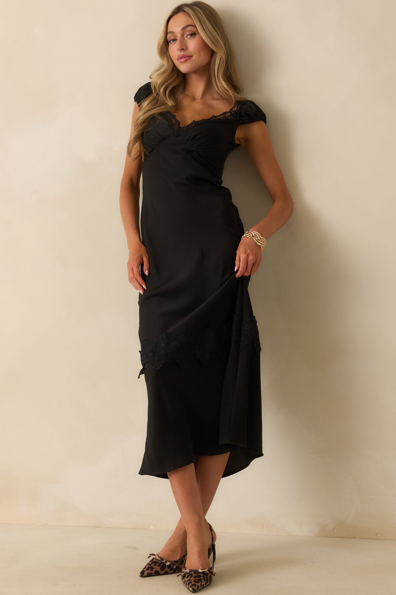 Black midi dress with silky fabric and lace trim along the v-neckline.