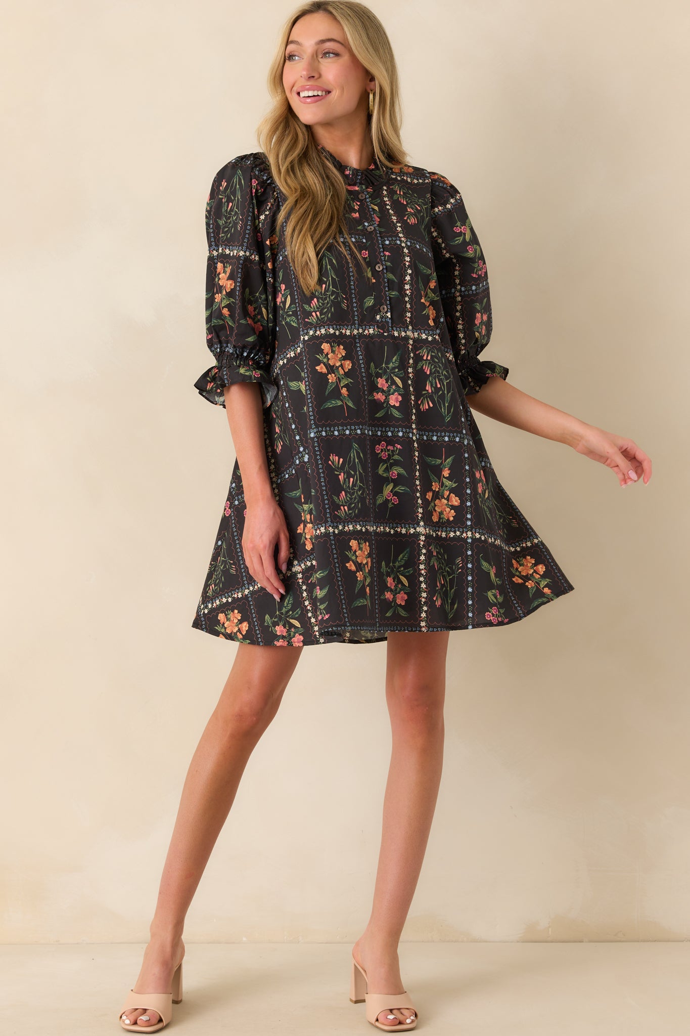 An angled full body photo showing the puff sleeves with ruffled cuffs and overall flow of the mini dress.