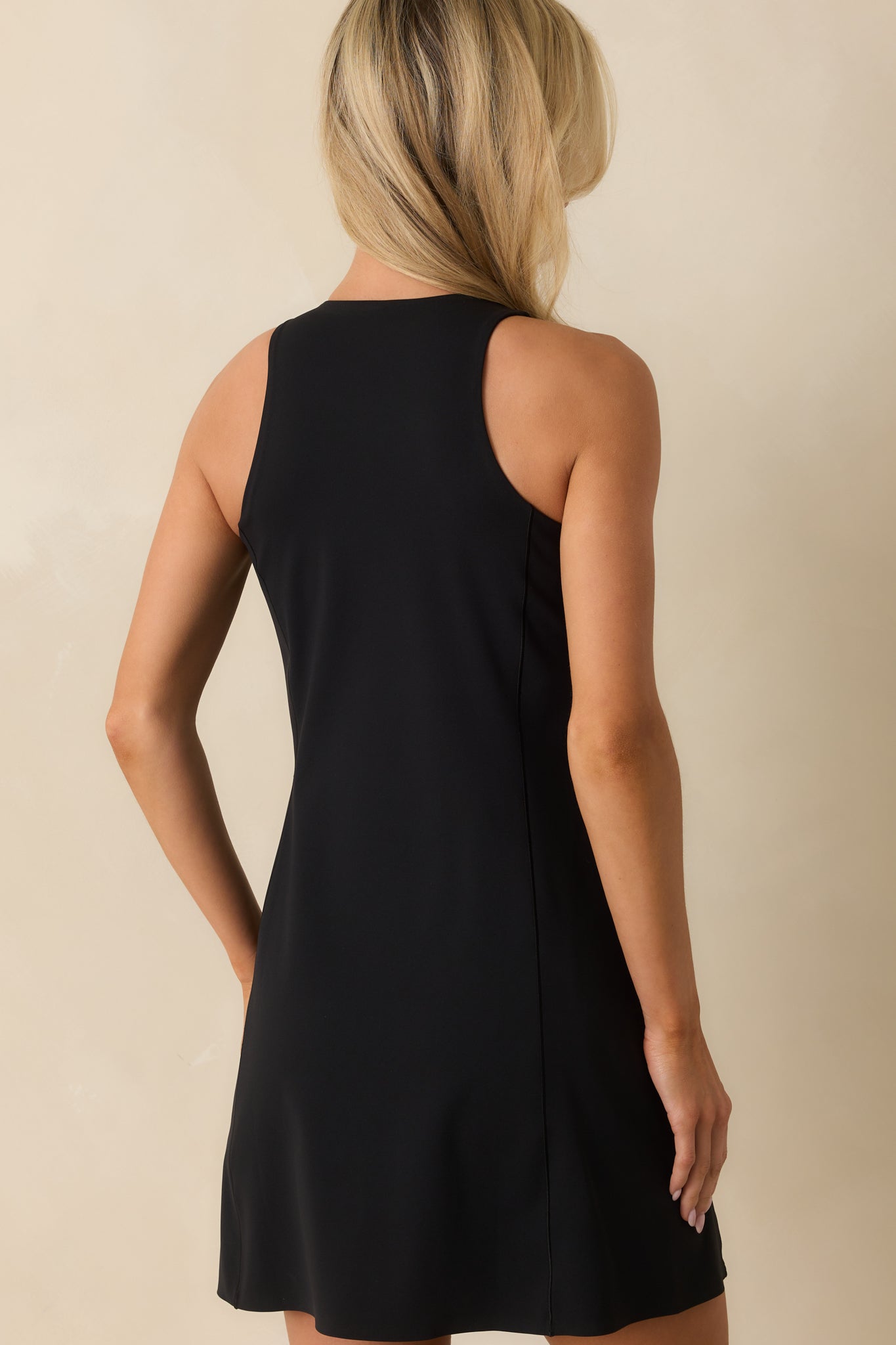 Rear view of black SPANXshape™ mini dress showing sleek stretch fabric and fitted silhouette.