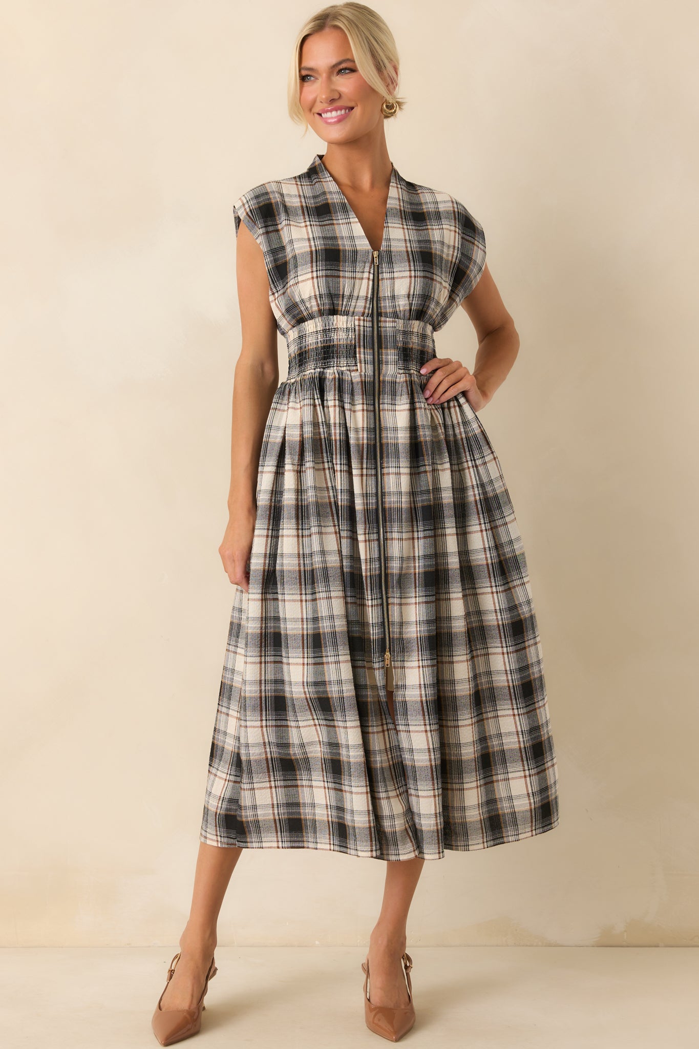Full view of the black plaid midi dress with a v-neckline, smocked waist, and visible zipper running down the front