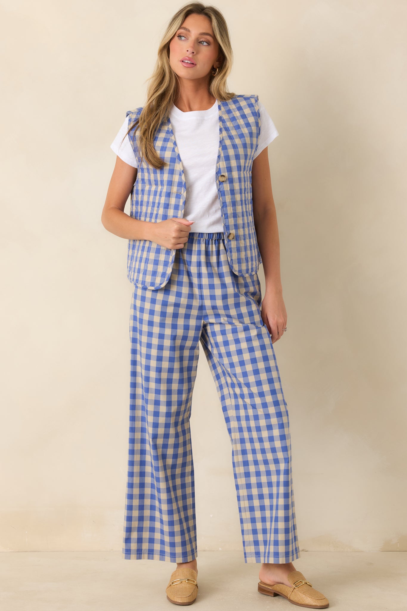 Front view of a blue gingham quilted vest styled with coordinating gingham wide leg pants and a white crewneck tee.