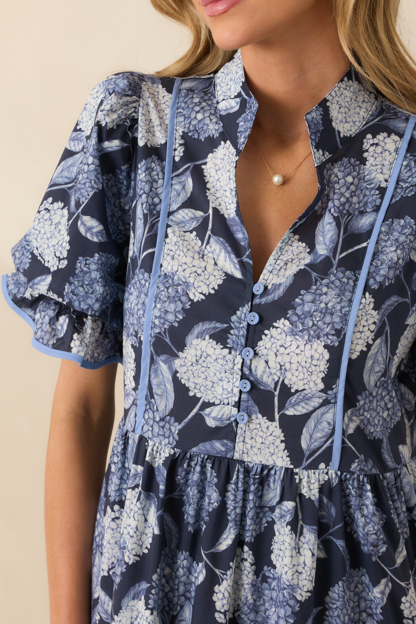 A close-up detail shot of the hydrangea print maxi dress showing the notch neckline and button front.