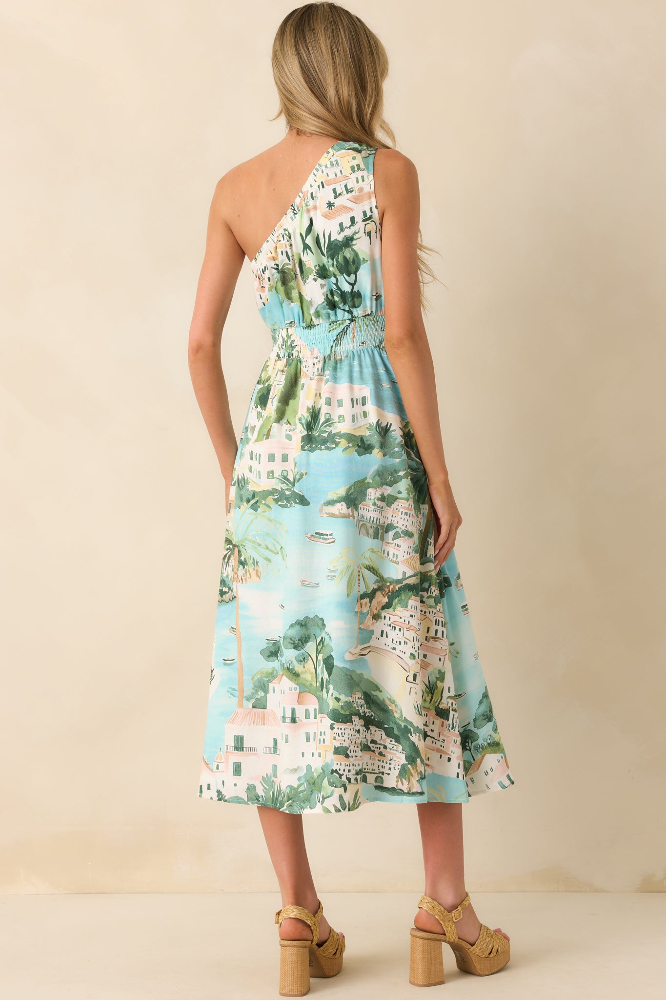 Rear view of the dress displaying the continuation of the blue watercolor print, one-shoulder neckline from behind, and skirt flow to the hem.

