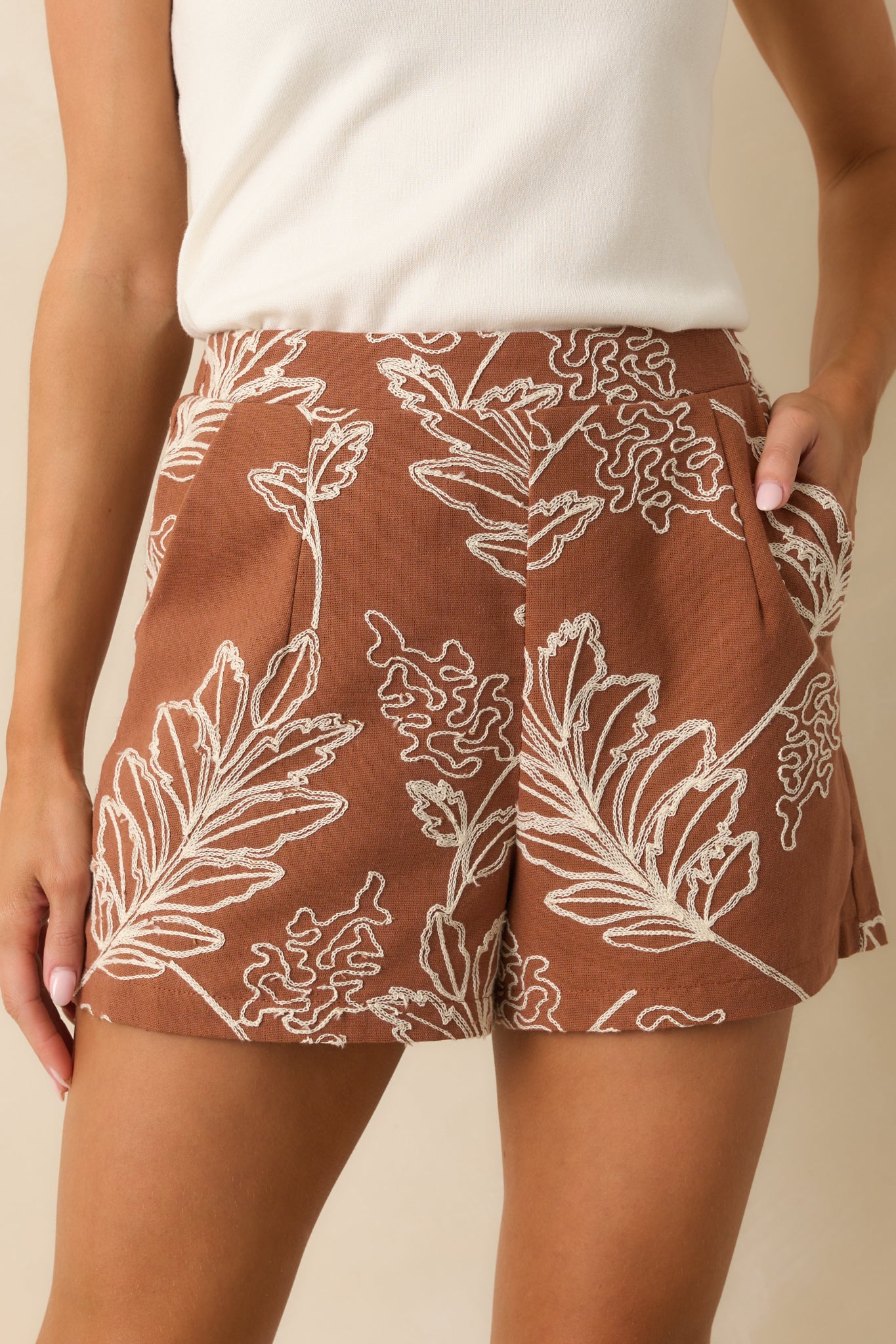 Detailed embroidery and pleat design on the brown shorts with full lining.