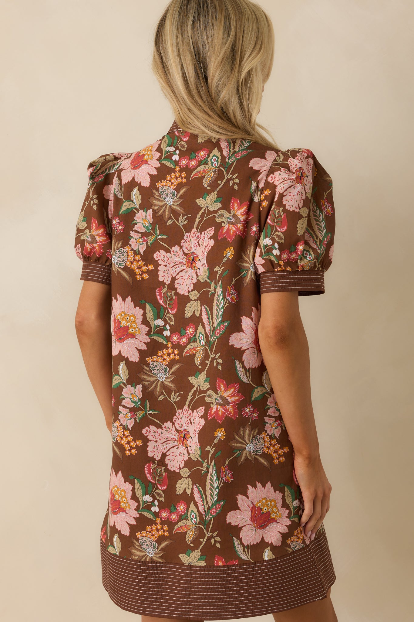 A view from behind of the mini dress showing the puff sleeves and overall back silhouette.