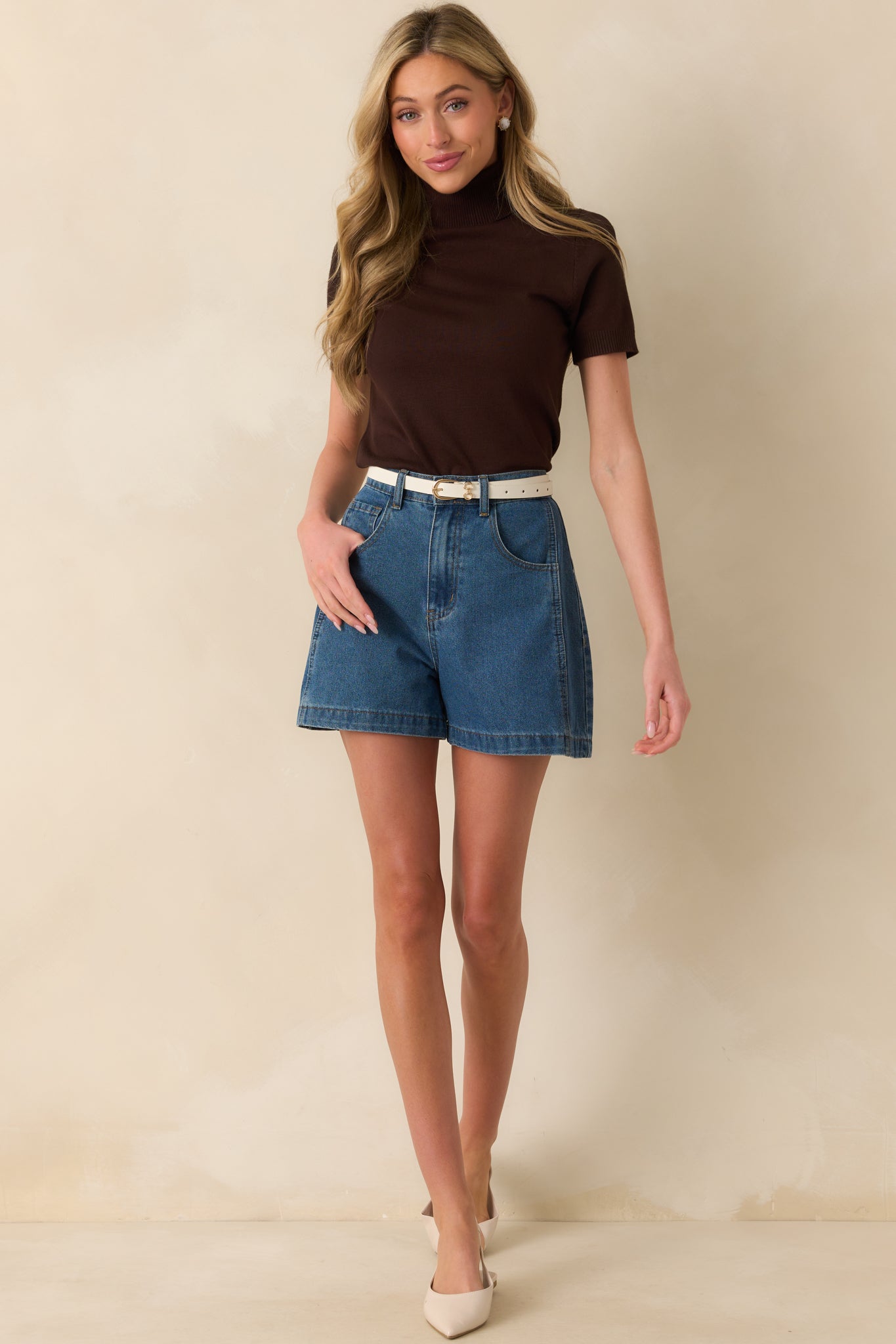 Straight-on front view showing the texture of the ribbed knit and the structure of the rolled neckline.