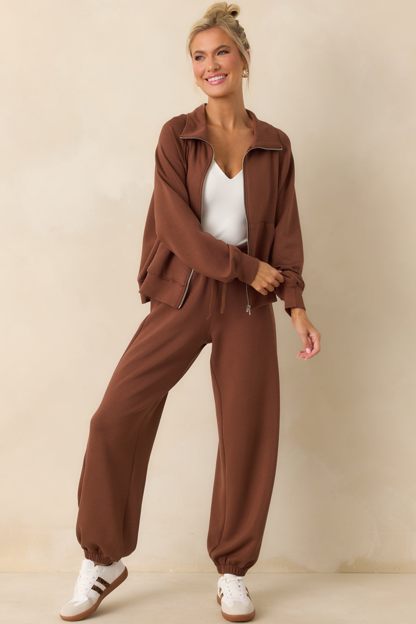 Full view of the brown jacket with collared neckline and zip front closure.