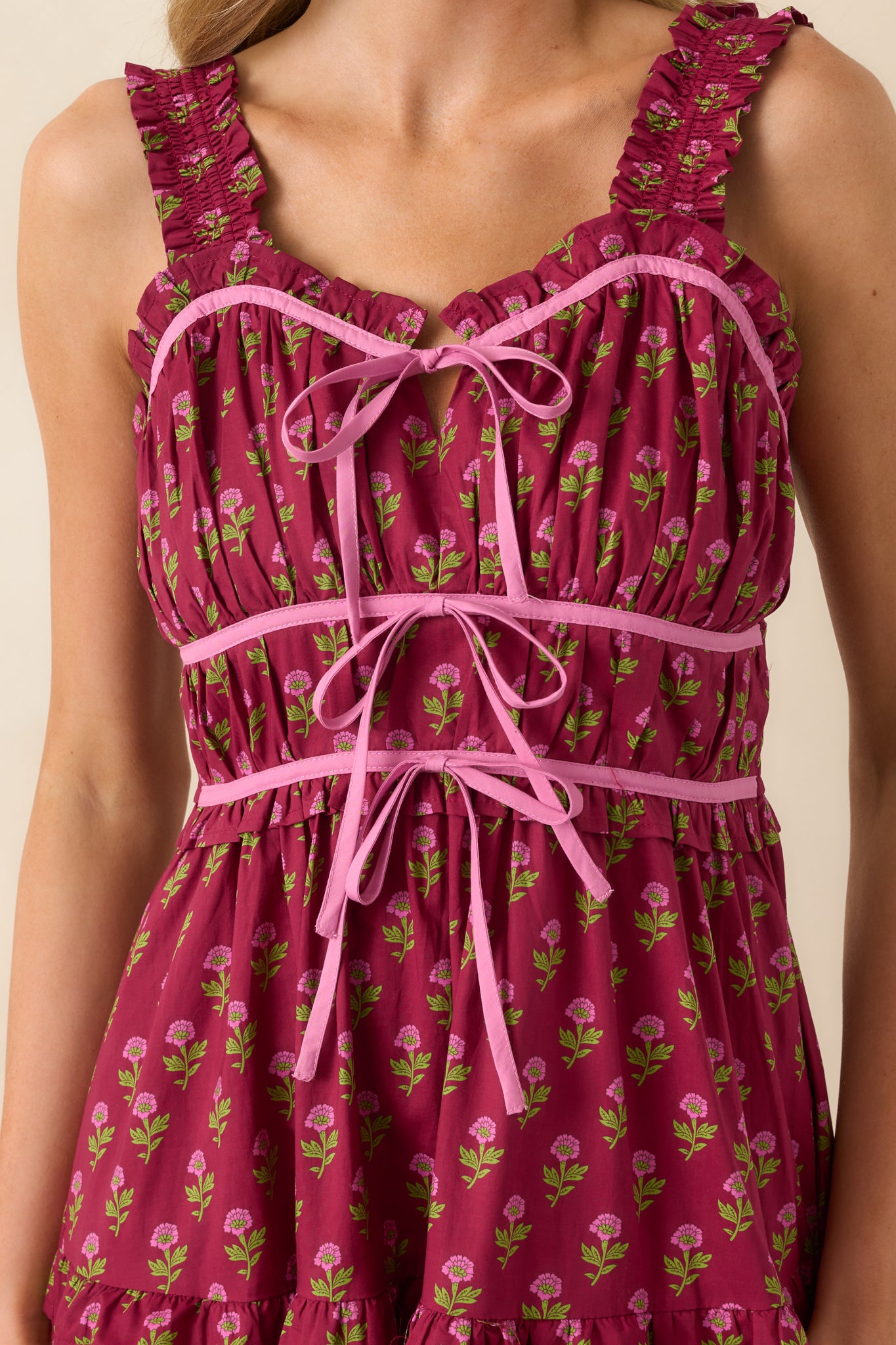 Close-up of the ruched bust, ruffle trim, and floral print showing the texture and color contrast.