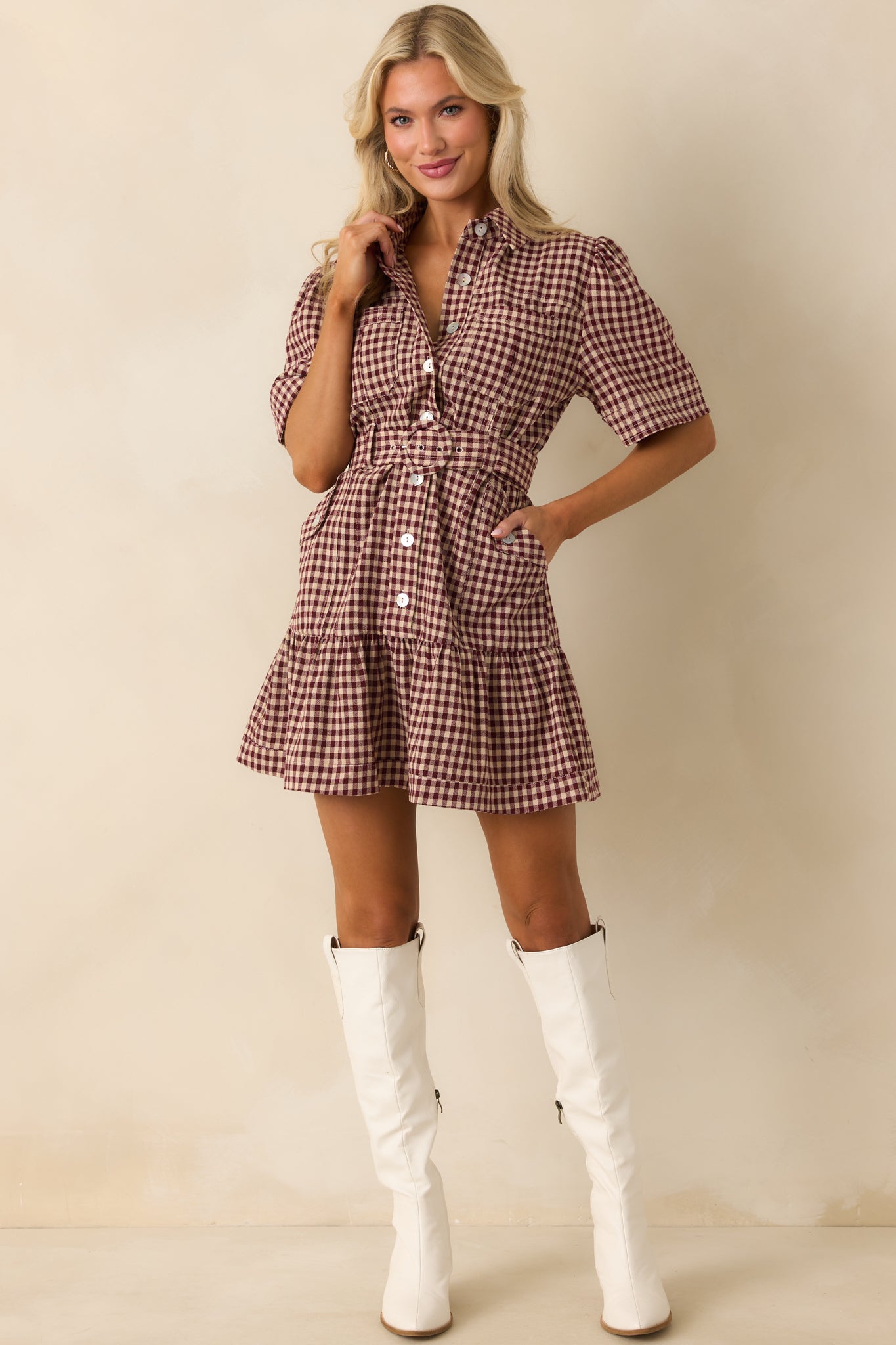 Burgundy gingham dress displayed in full, showing both waist patch pockets and the flow of the tiered skirt.