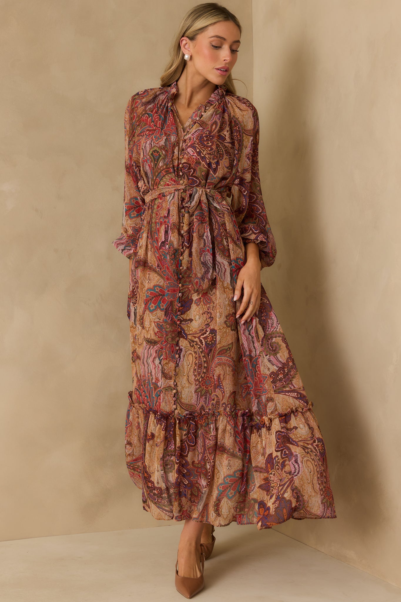 Burgundy maxi dress with multicolor paisley print, ruffle neckline, and tiered ruffle trim skirt.