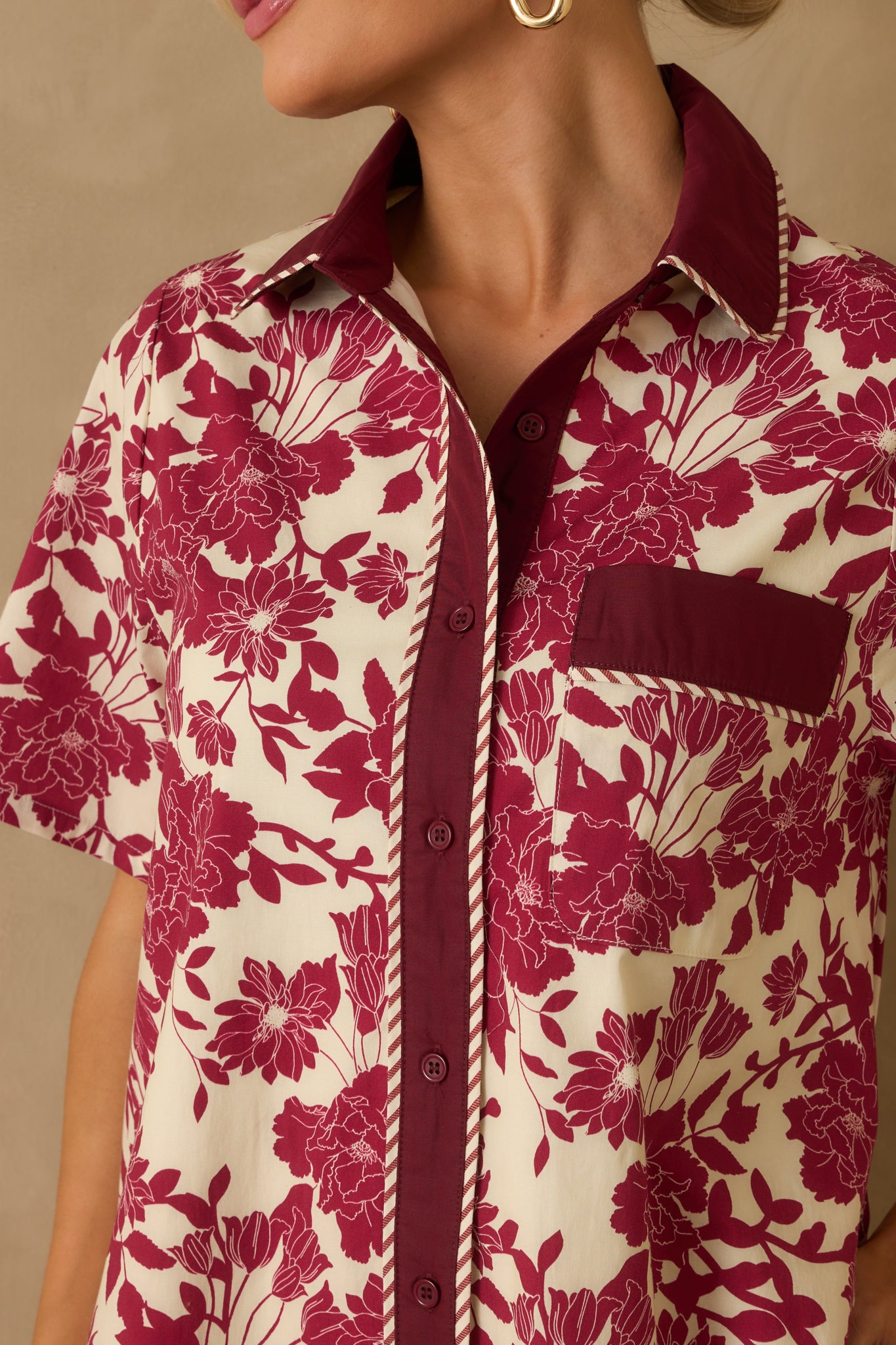Collared neckline with button placket and ivory floral print fabric.