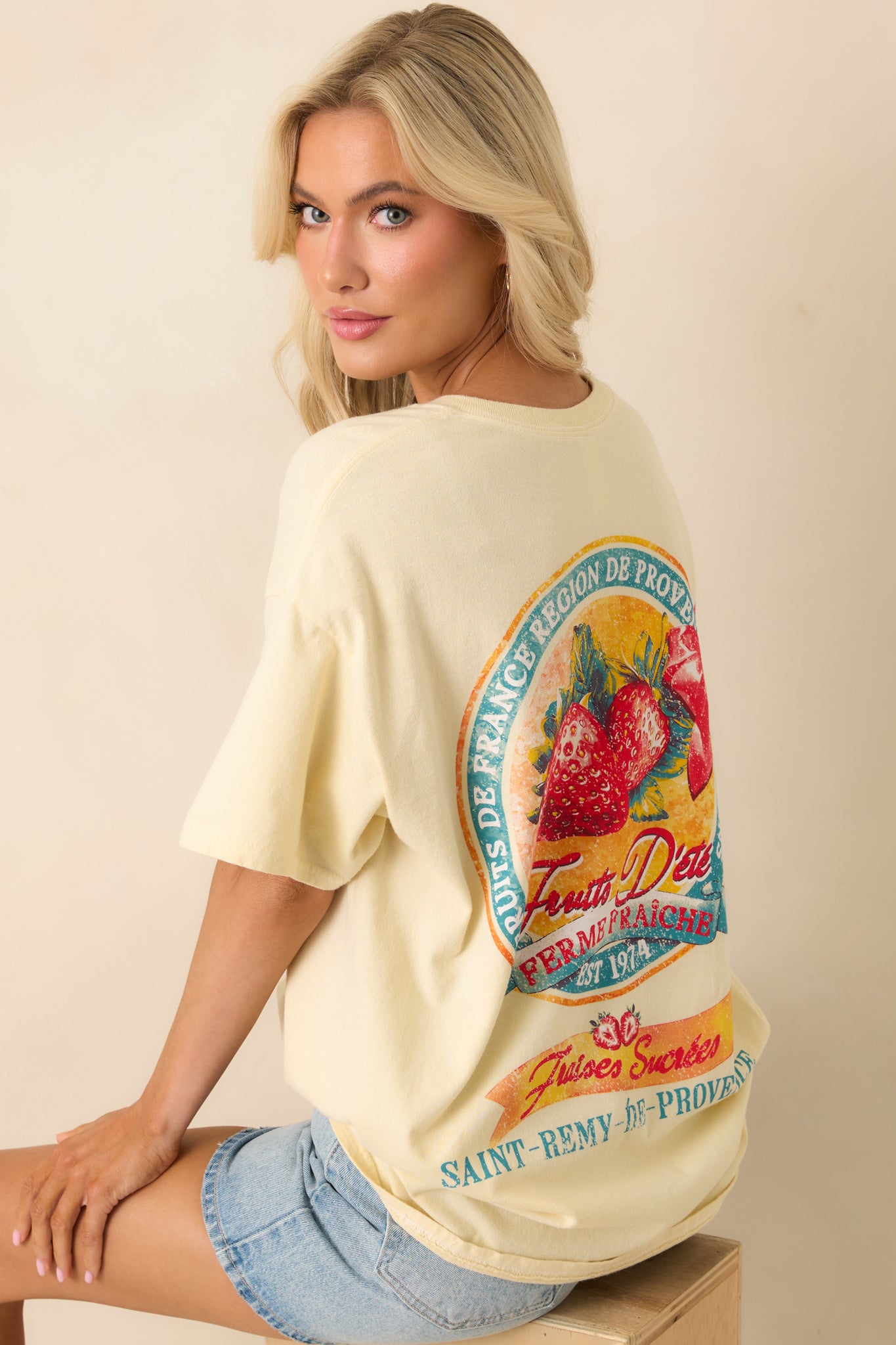 An angled back view highlighting the size and placement of the distressed strawberry print under the shoulders.
