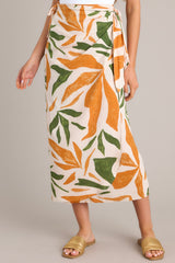 Front view of this tropical print midi skirt that features a high waisted design, an elastic waist insert, self-tie wrap features, an orange & green tropical print, and a lightweight fabric.