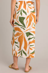 Back view of this tropical print midi skirt that features a high waisted design, an elastic waist insert, self-tie wrap features, an orange & green tropical print, and a lightweight fabric.