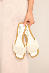 Top view of  these ivory flats that feature a square toe, a slip-on design, and a strap across the top of the foot with a knitted texture. 