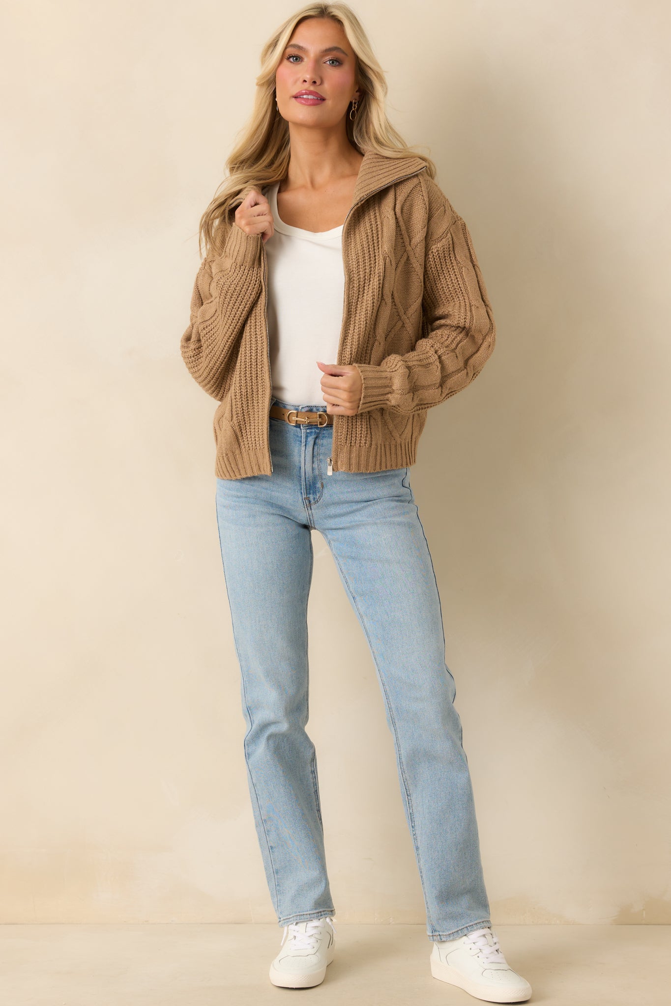 Camel brown cable knit jacket with a fold-over collar and ribbed hems shown fully zipped.