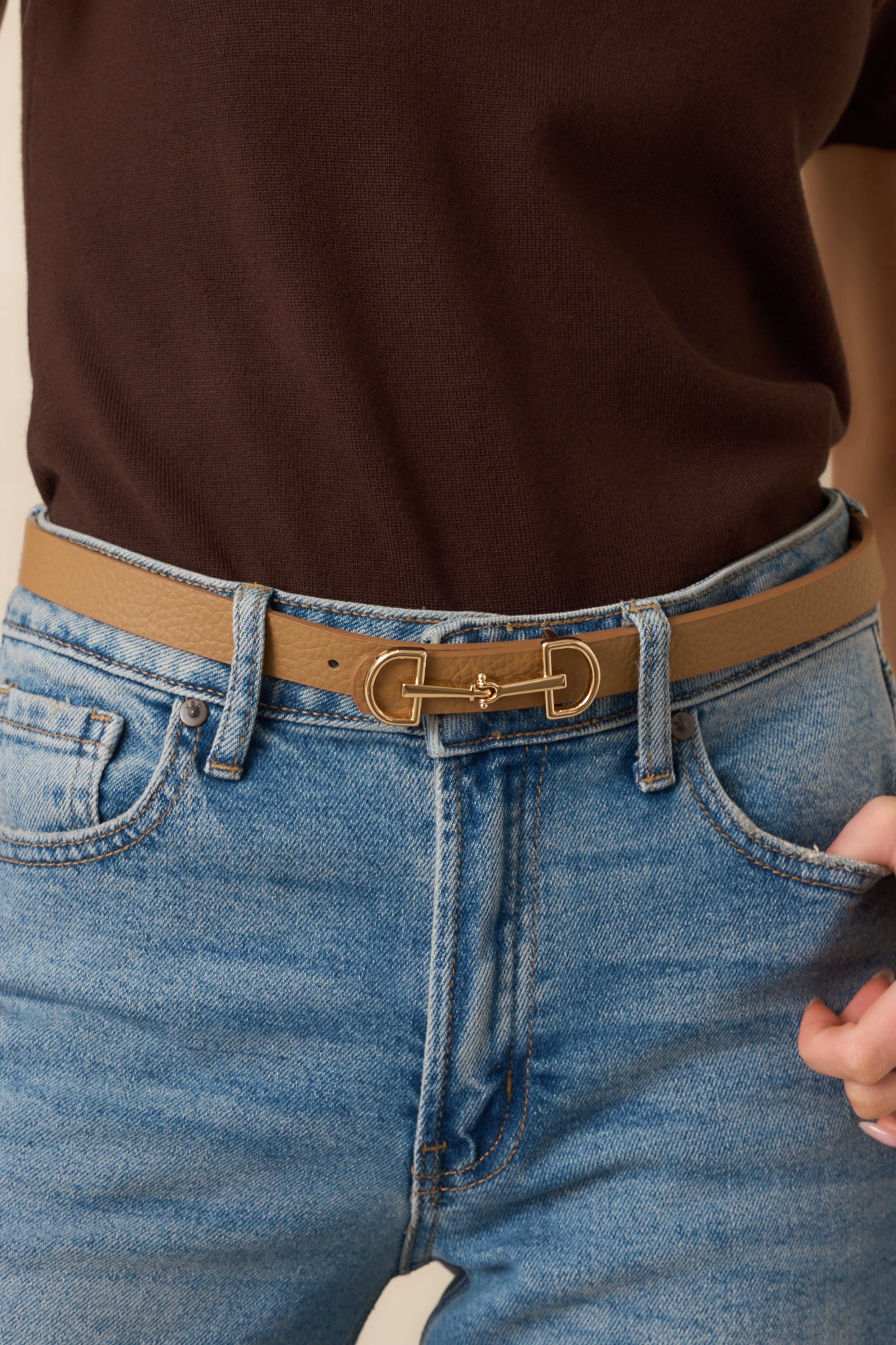A close-up of the anchor buckle closure and gold hardware, emphasizing the textured surface of the faux leather.