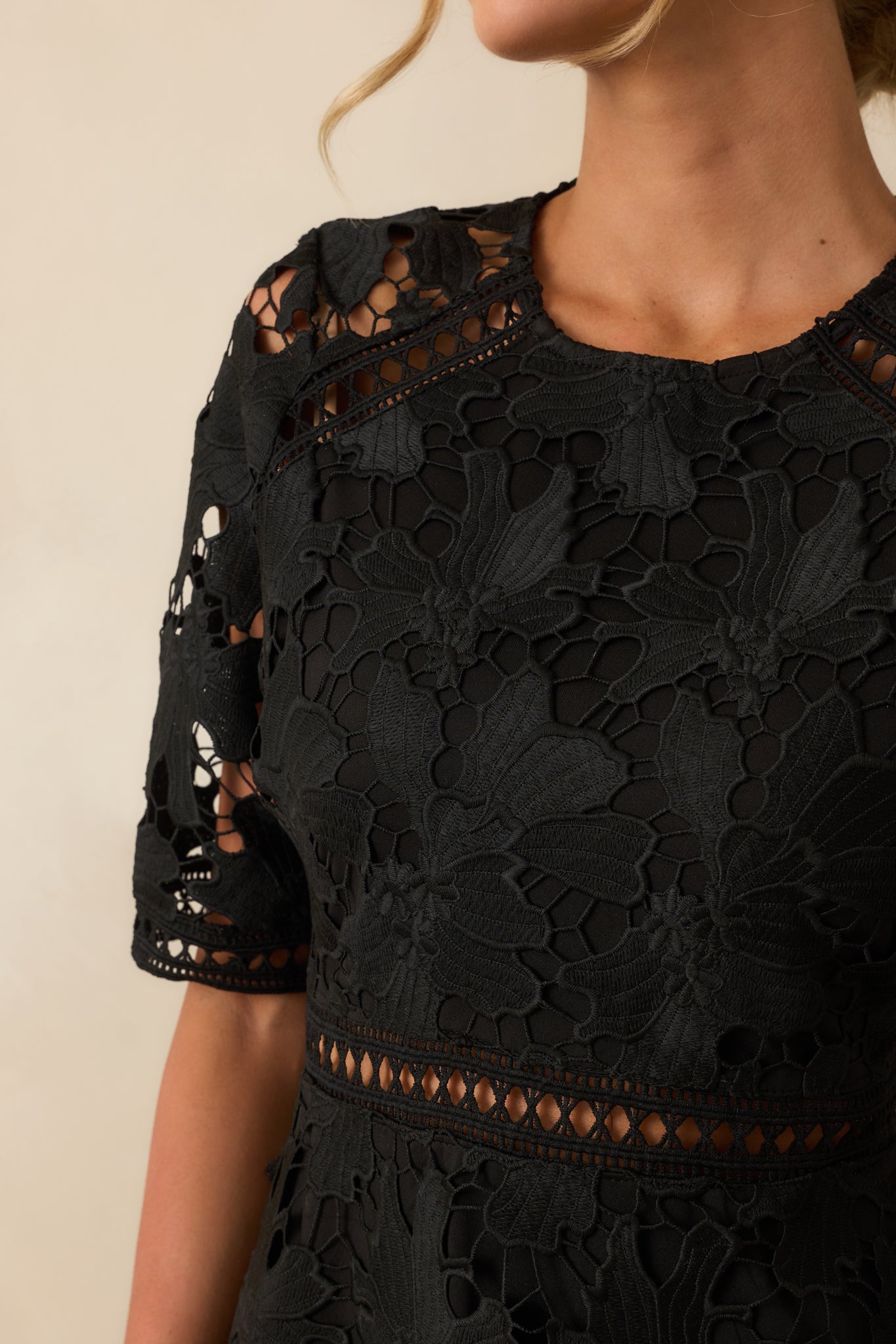 Close-up of the lace overlay and open ladder lace details on the black dress.
