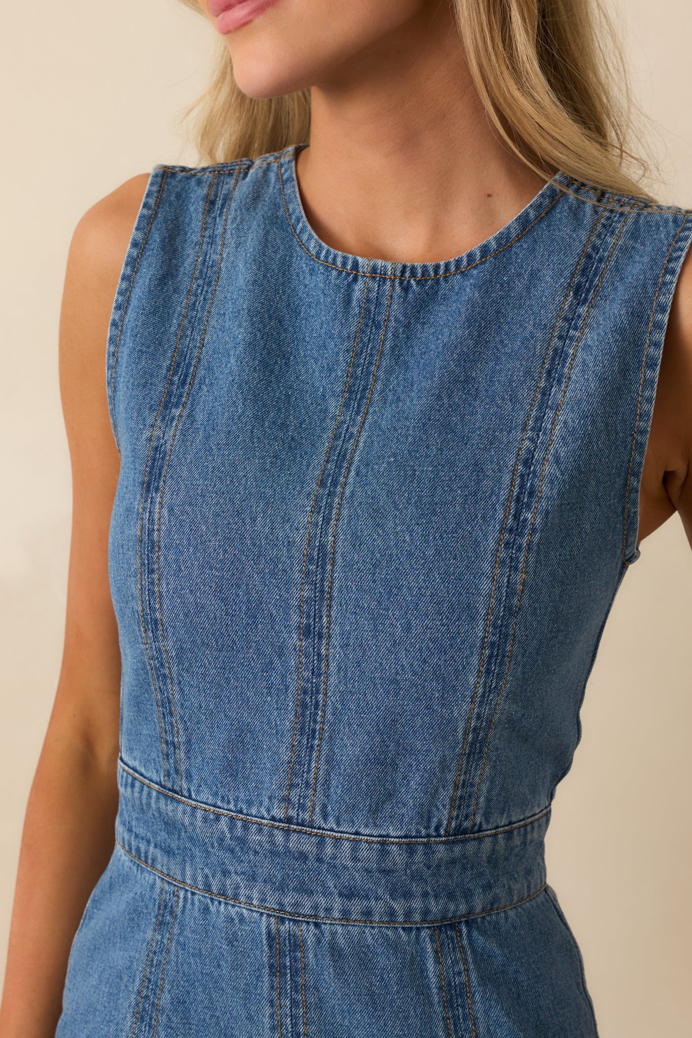 Close-up of the paneled bodice and crew neckline on the medium wash dress.