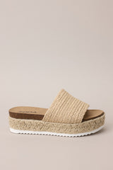 Side view of these natural sandals with rounded toe, slip-on design, strap over foot, espadrille detailing, textured sole.
