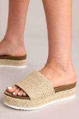 These sandals boast a rounded toe and a convenient slip-on design, complemented by a strap over the top of the foot for added style and security. Featuring charming espadrille detailing and a textured sole, they offer both comfort and flair.