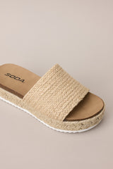 Overhead view of these natural sandals with rounded toe, slip-on design, strap over foot, espadrille detailing, textured sole.