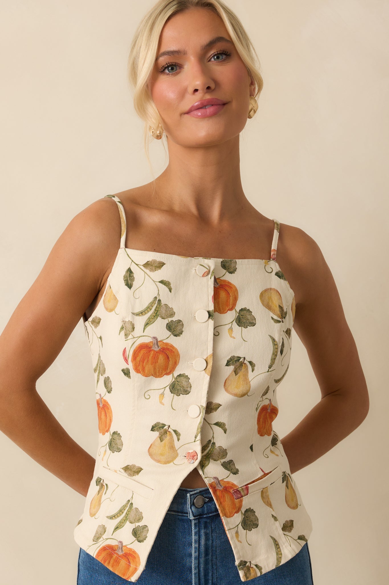 Cropped front shot of ivory garden-print top highlighting button-front closure and square neckline.