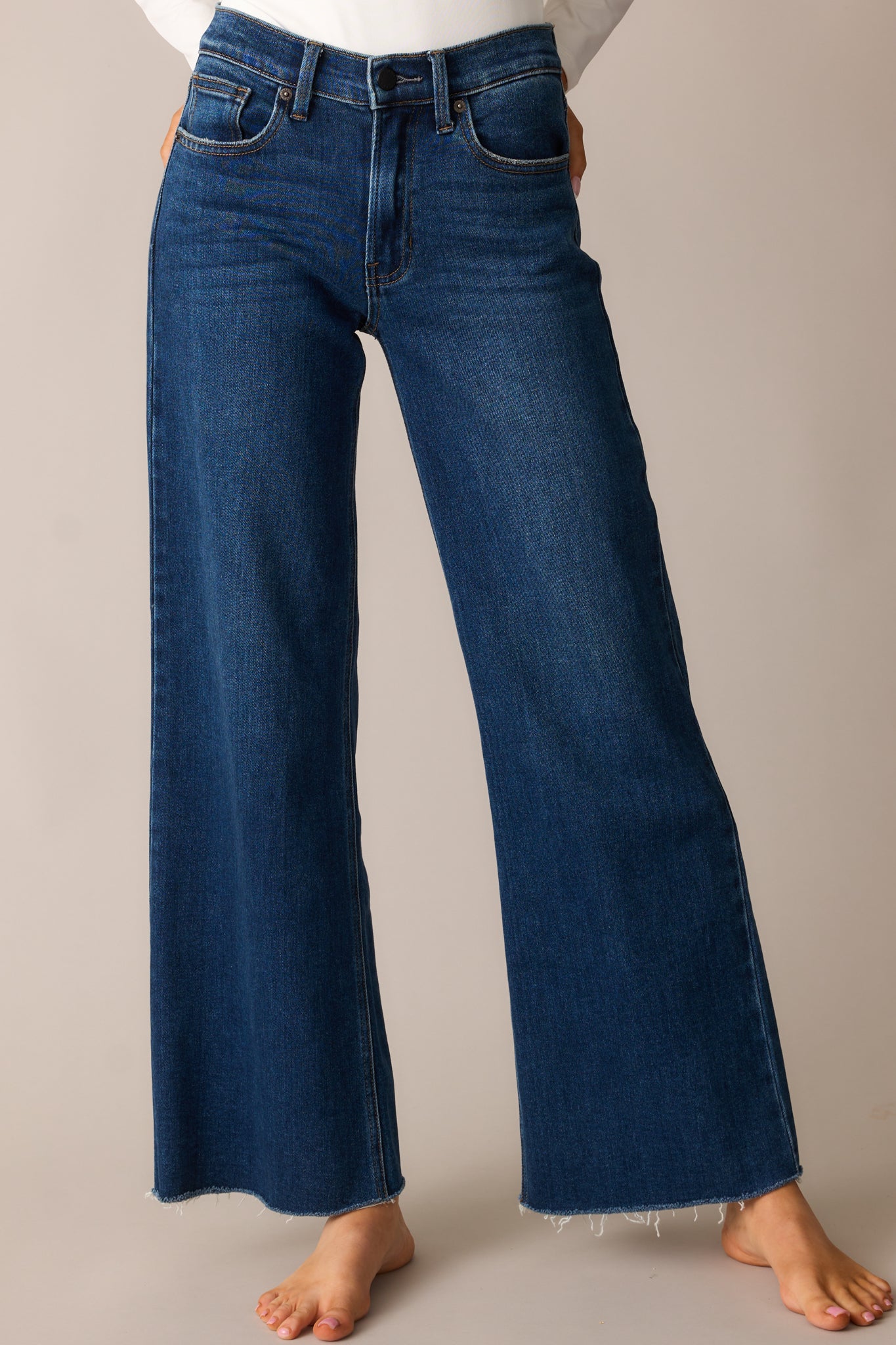 A closer look at the jeans’ high-waisted fit, structured waistband, belt loops, and functional front pockets.
