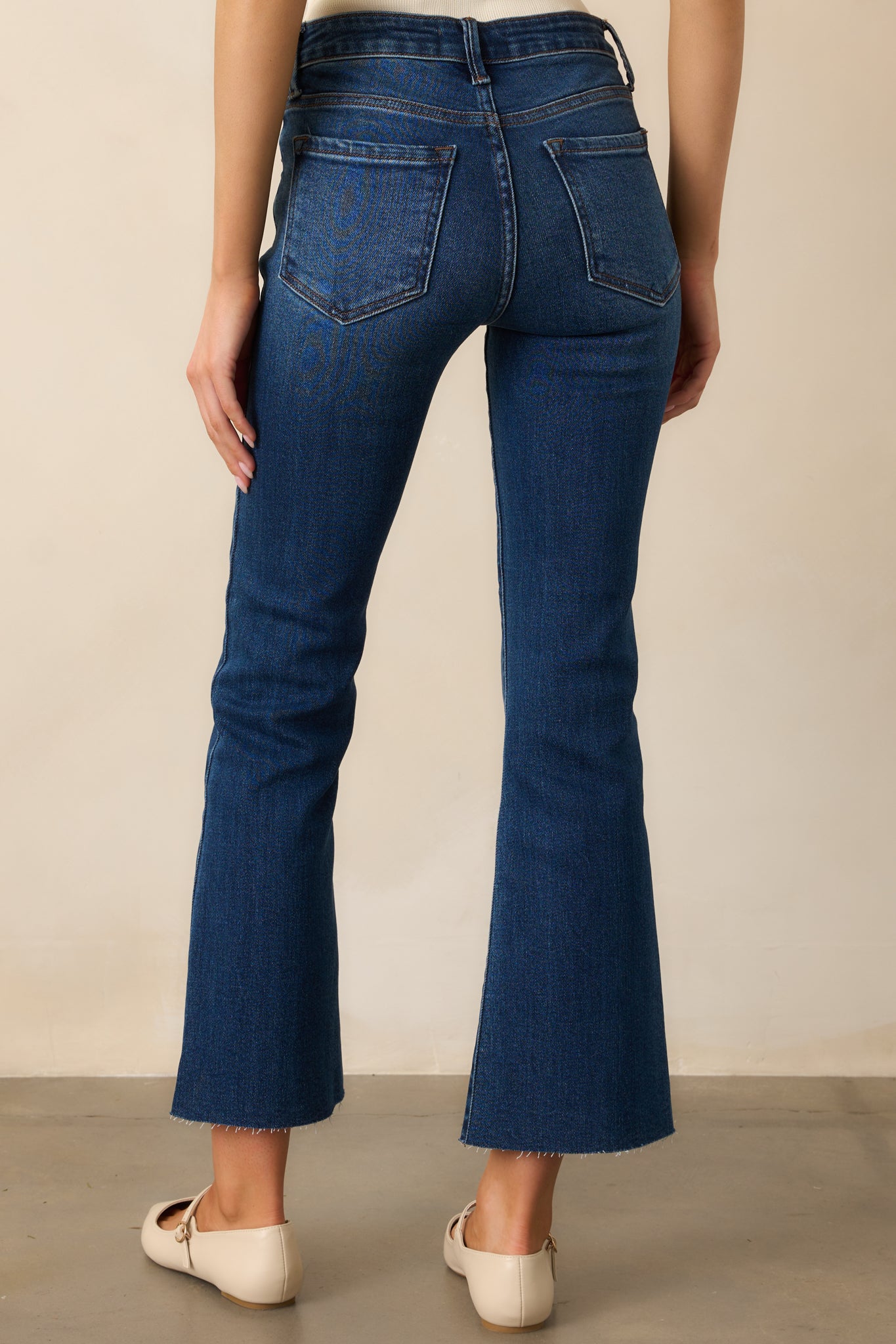 Back view of the dark wash jeans featuring functional back pockets, a high-waisted fit, and a flared leg for a timeless, polished style.