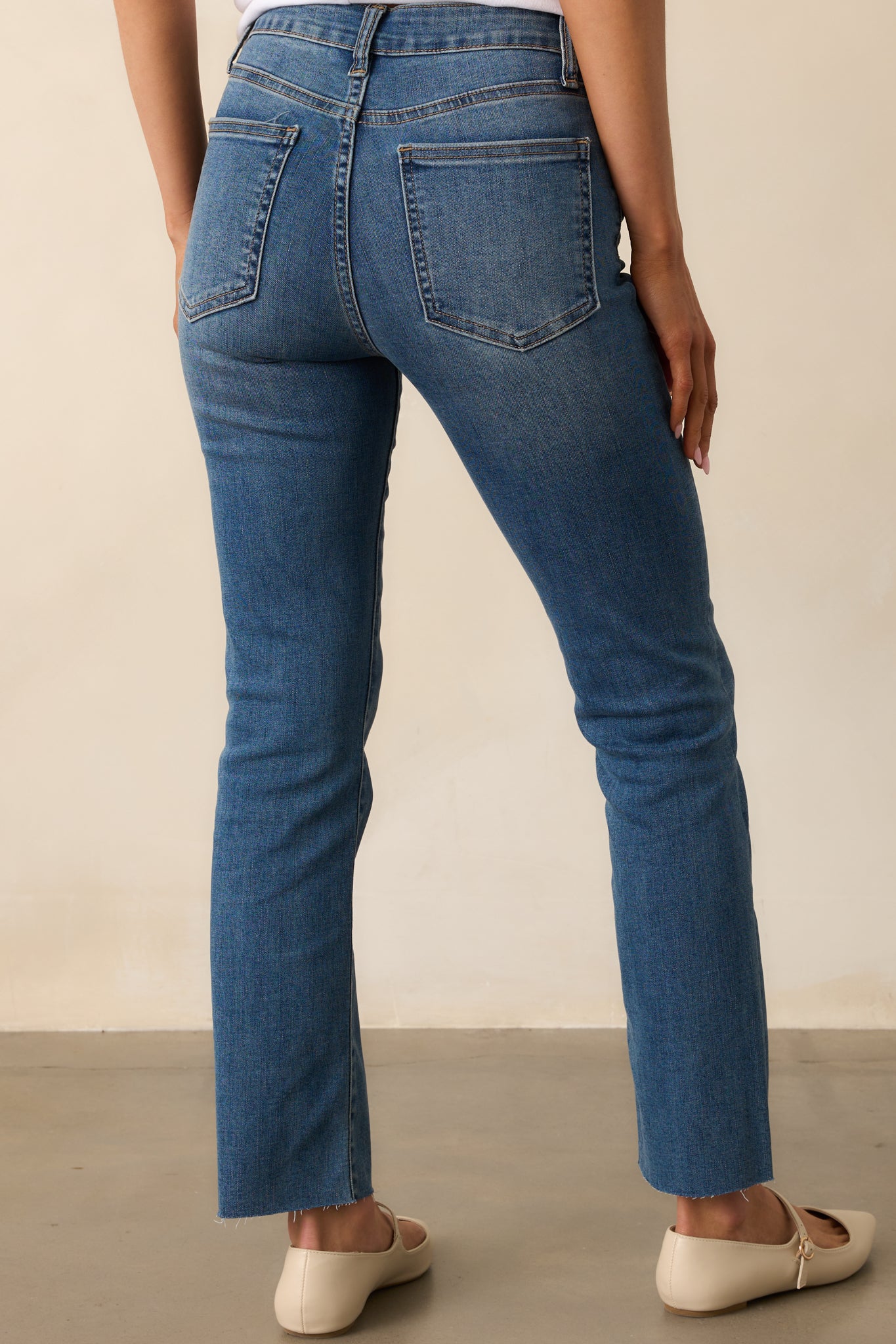 A back view of the high rise dark wash jeans, featuring functional back pockets and a clean, structured back seam.