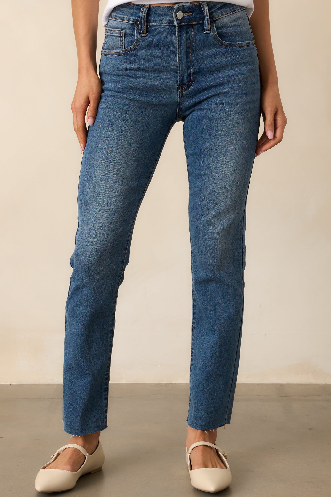 A close-up of the thigh and knee area of the straight leg jeans, showing fabric texture and stitching details.