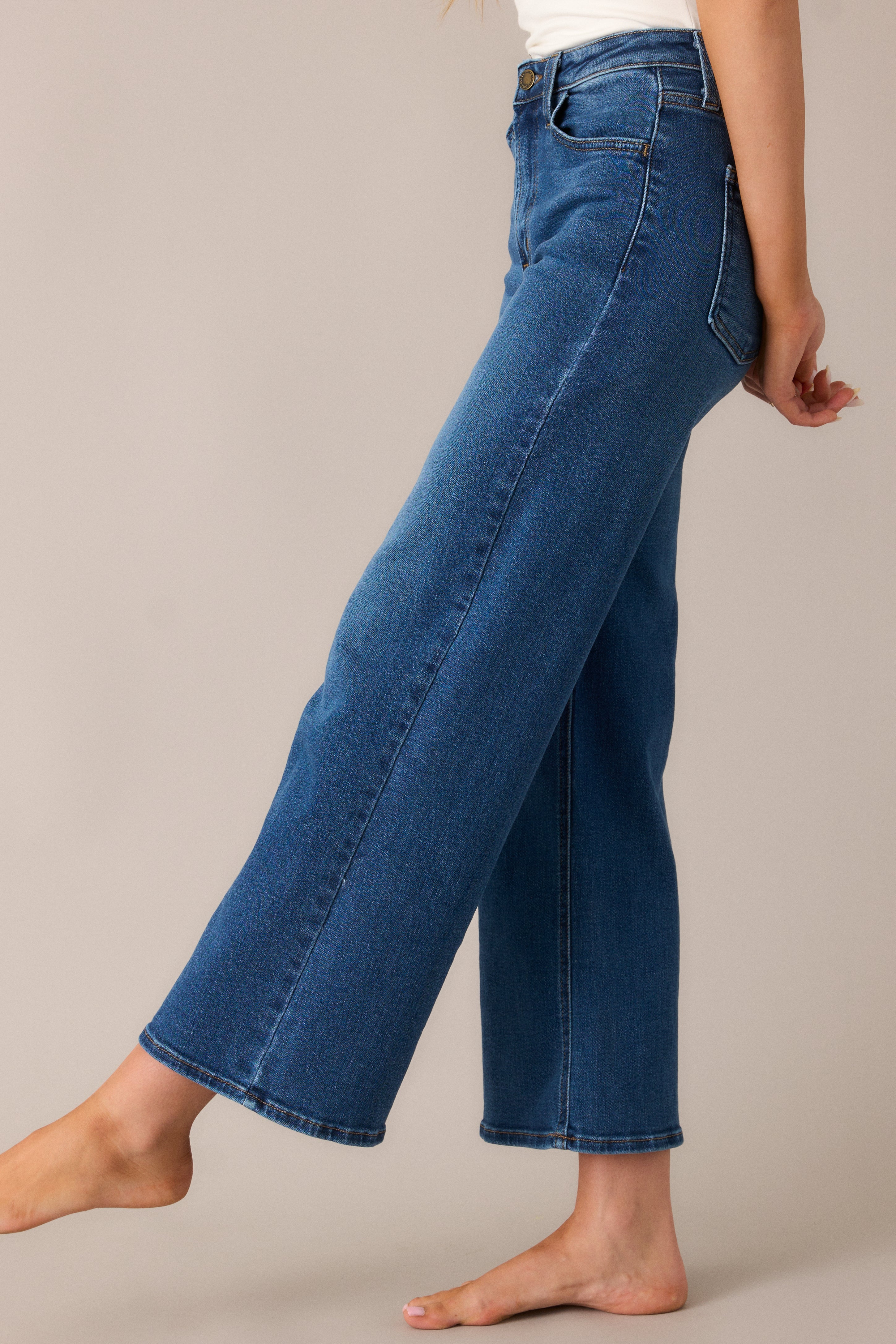 Stylish wide-leg jeans with a slightly cropped length and high waist, featuring functional belt loops and pockets, designed for a relaxed yet fashionable look.