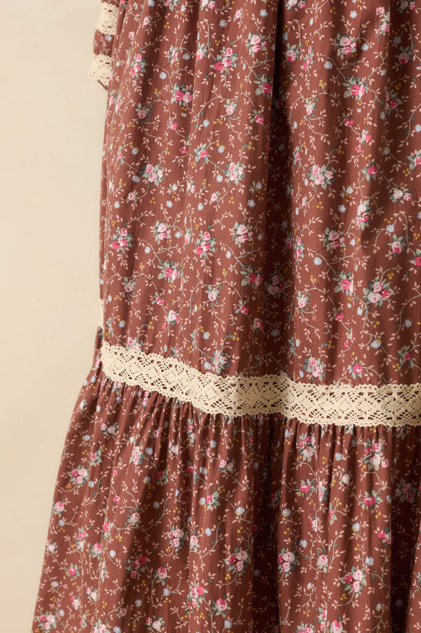 Detailed view of the floral print, lace trim accents, and smocked bodice texture on the mocha midi dress.