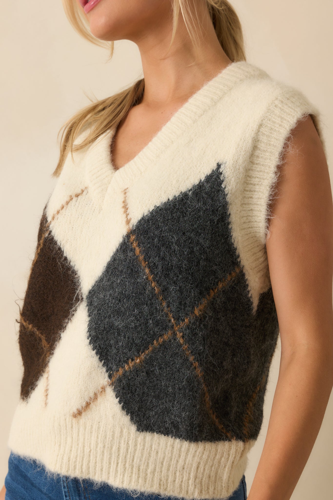 Detailed view of the brown and grey argyle pattern and knit texture on the vest.