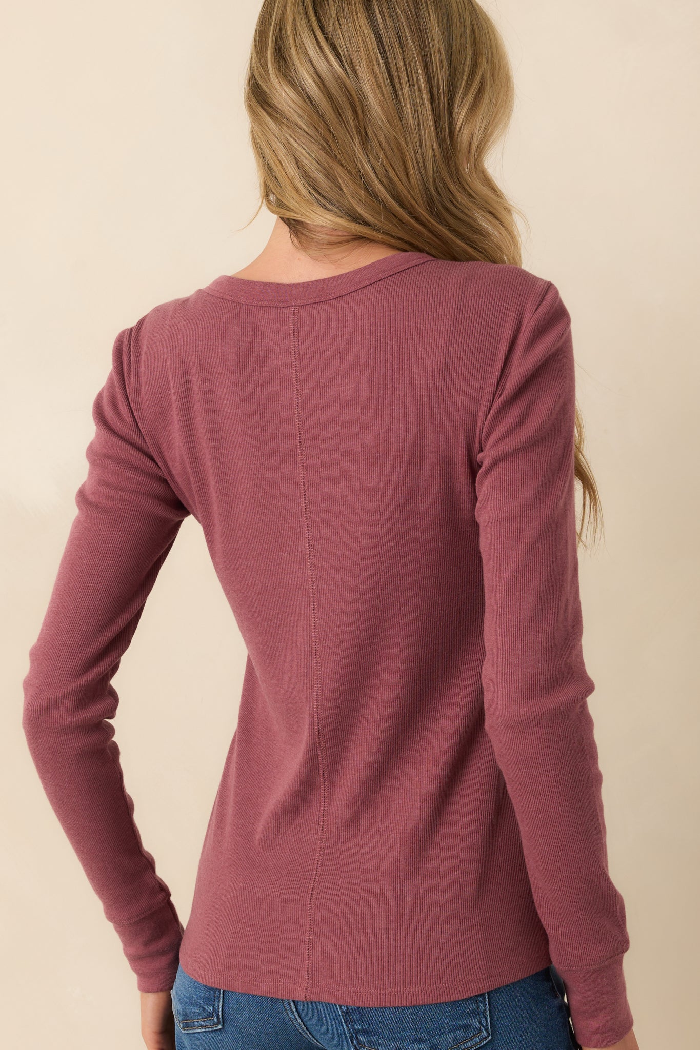 Rear view of the plum purple top displaying the center seam detail and smooth drape of the ribbed fabric across the back.