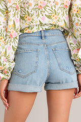 Close up back view of these light wash denim shorts that feature a high waist, classic button-zipper closure, functional belt loops, and five pockets.