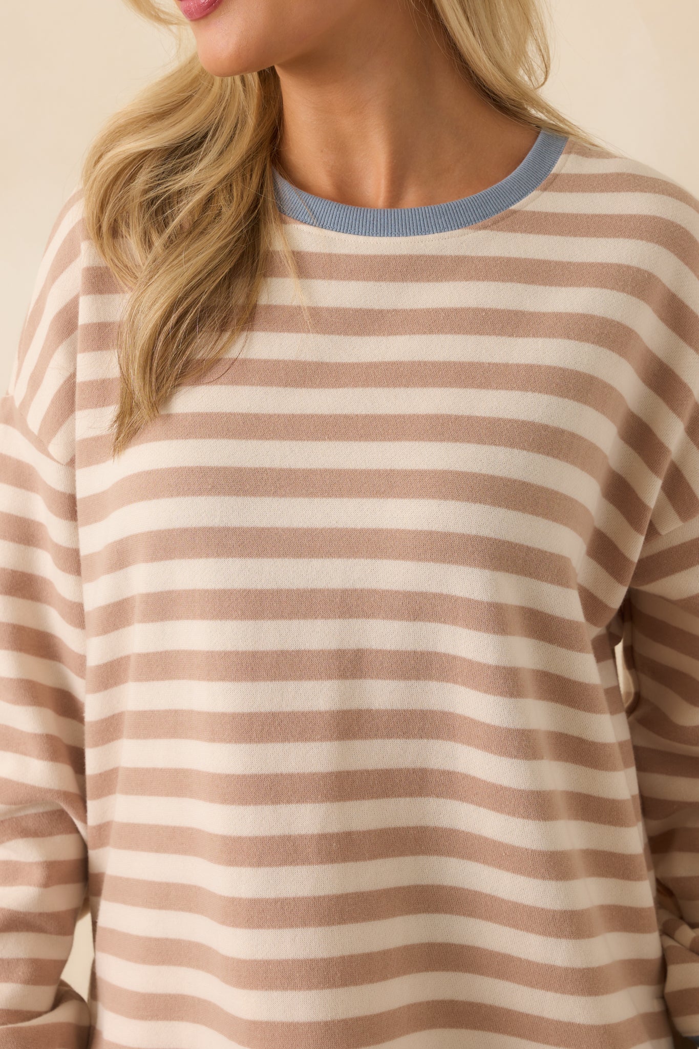 Fabric detail of soft fleece sweatshirt with beige and ivory stripe pattern.