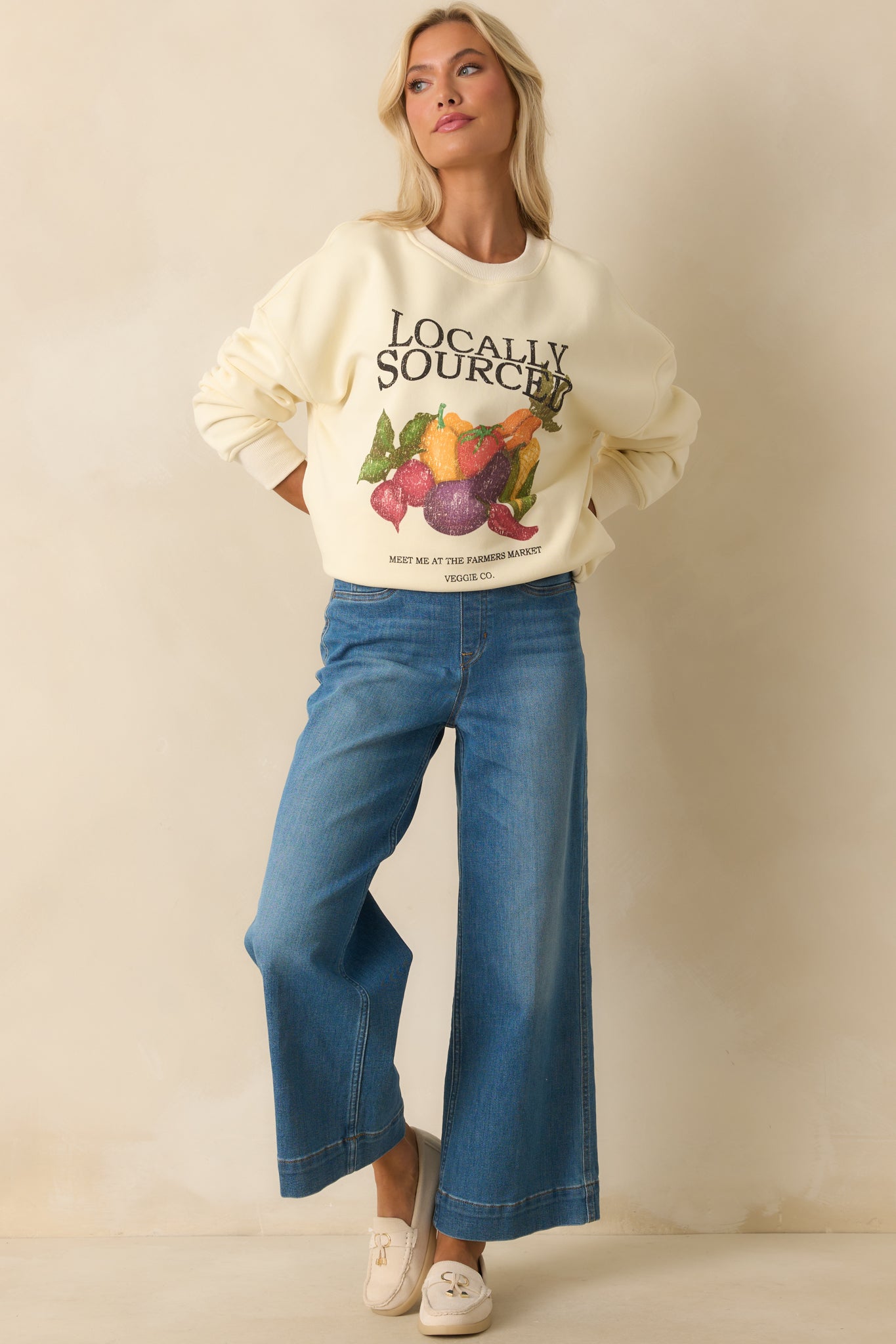 Front-facing view of ivory crewneck sweatshirt with relaxed fit and farmer’s market print.