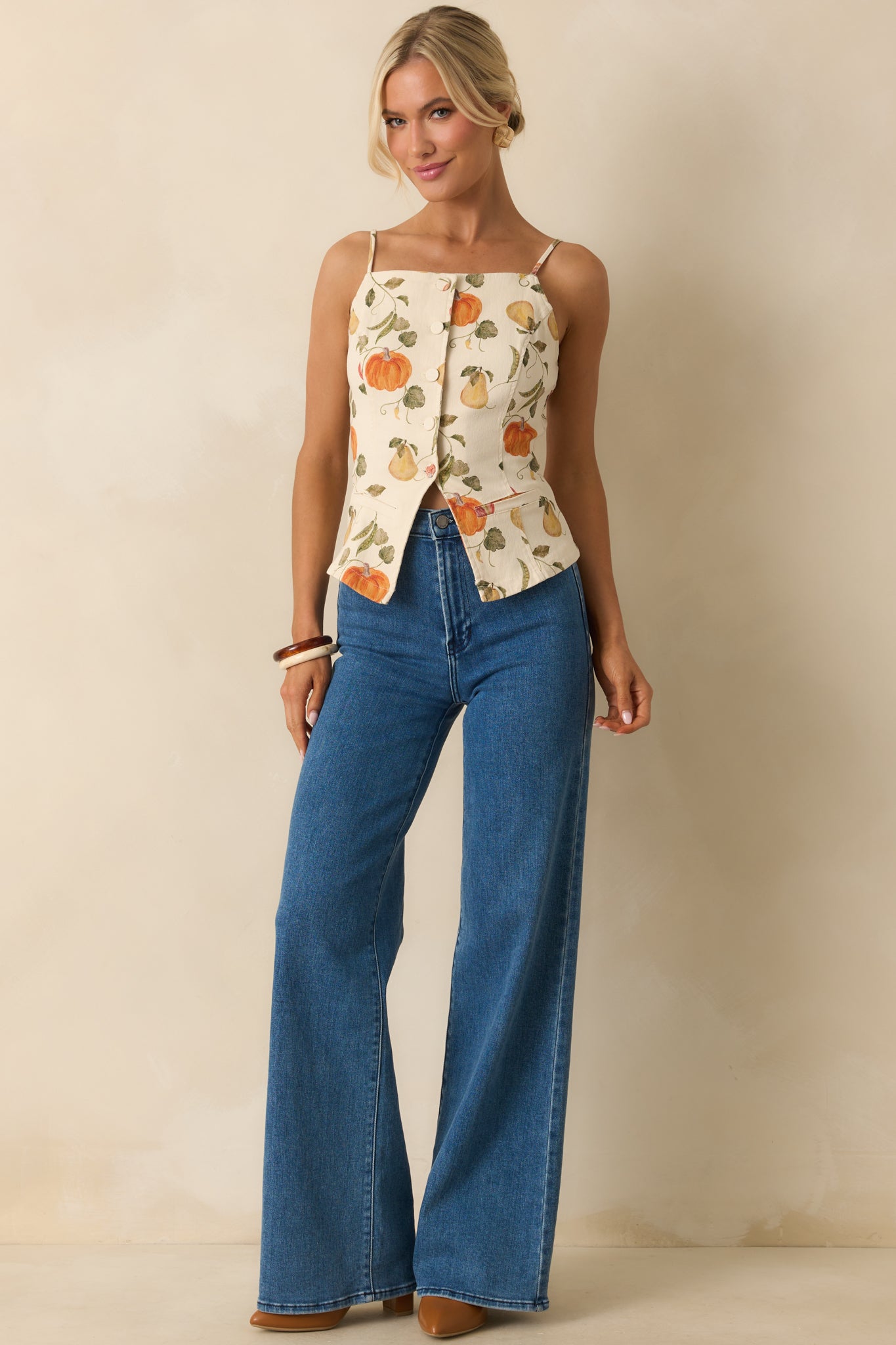 Front-facing view of ivory button-front top with spaghetti straps and faux pockets.