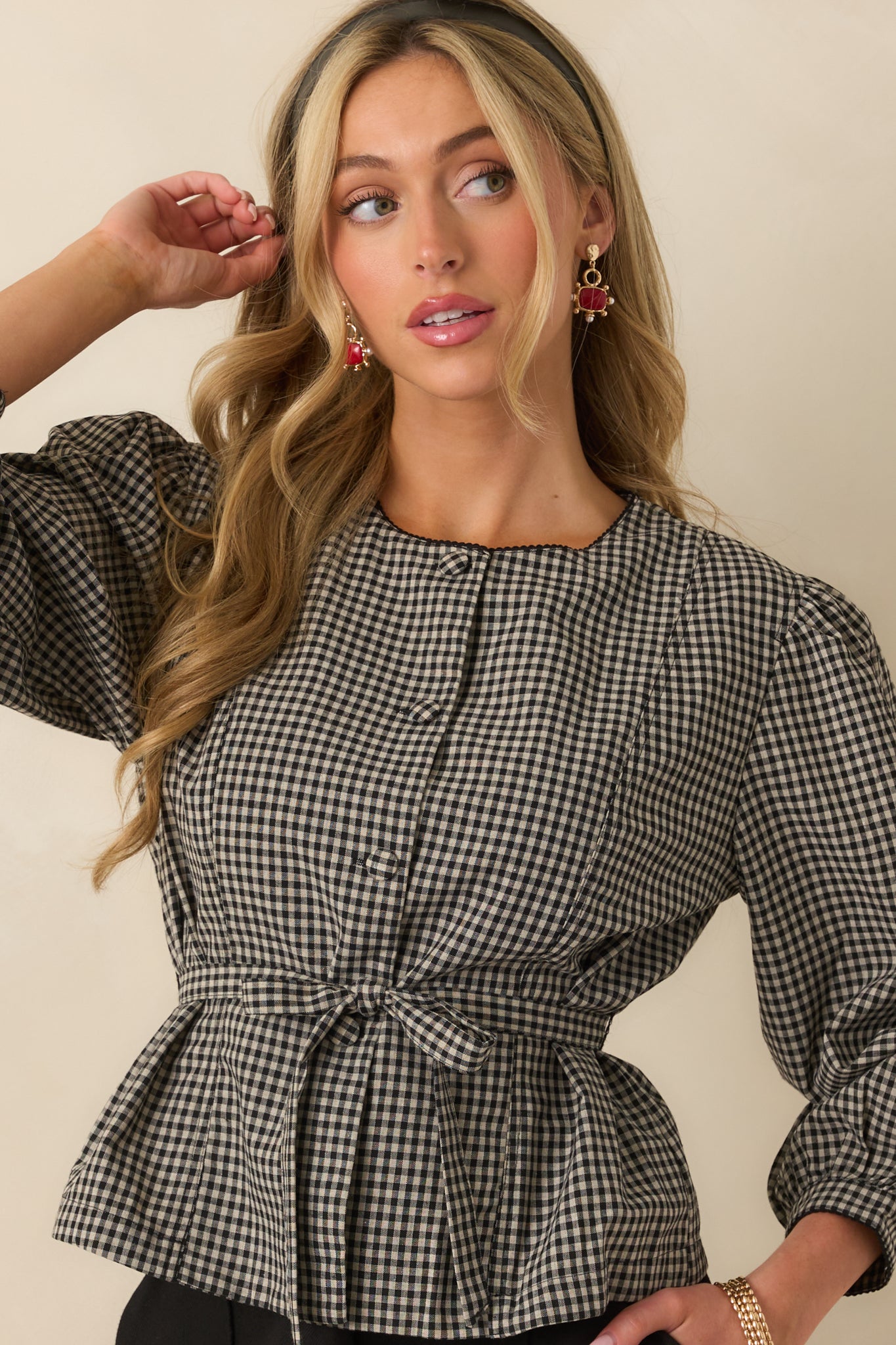 Cropped view of the neckline and button-up front of the gingham blouse.