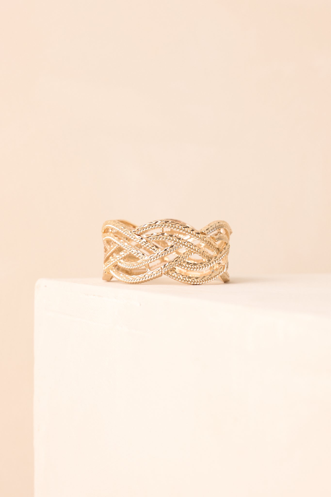 A close-up detailed side image revealing the diamond-cut texture and interwoven open braid of the gold bracelet.