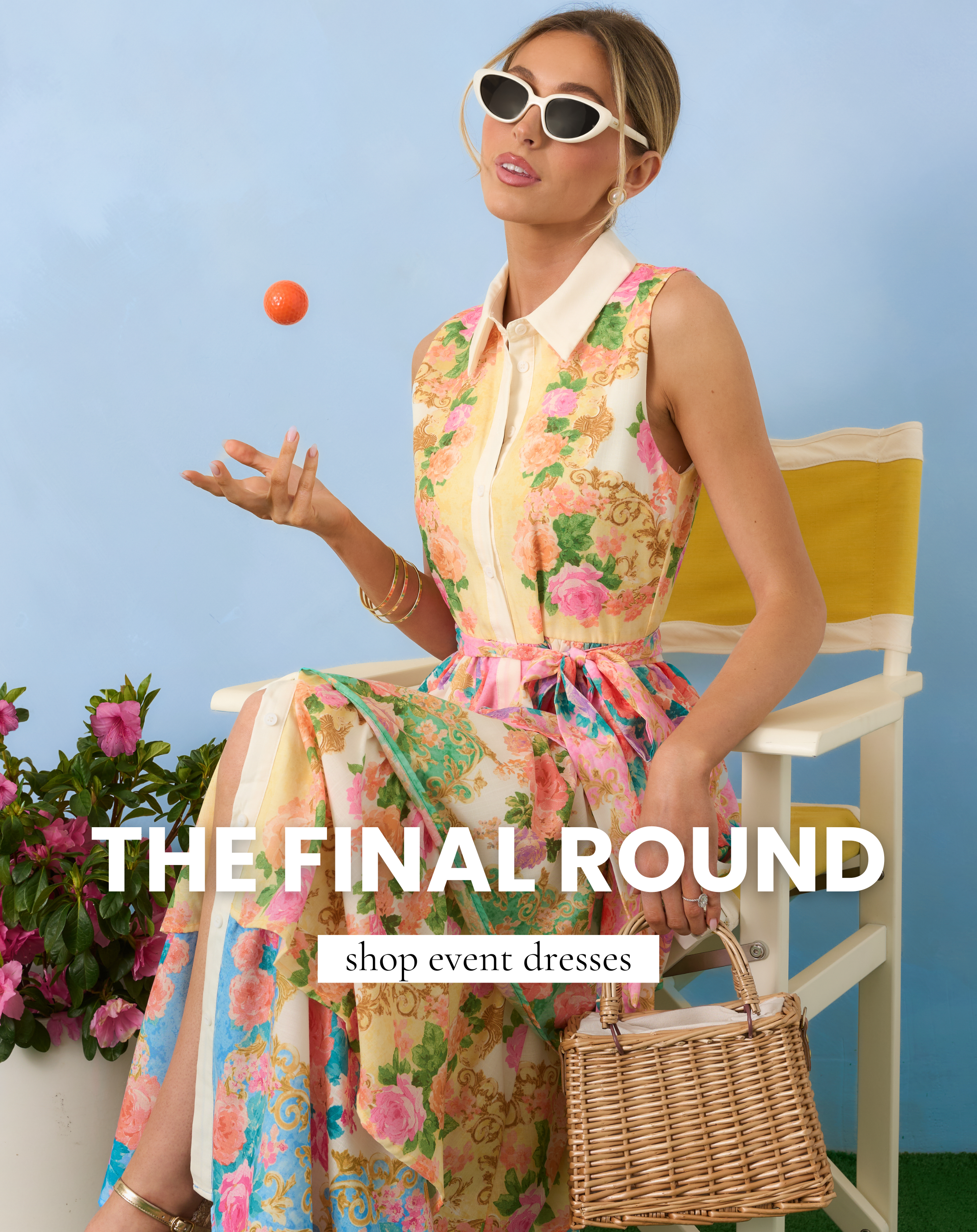Model wearing a sleeveless pastel floral midi dress with a collar and waist tie styled with sunglasses and a wicker handbag for our Final Round event dresses collection. This image links to shop event dresses perfect for golf tournament parties and spring celebrations. 