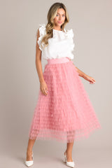 Full body view of this pink skirt that features a high-waist design with an elastic waistband for a comfortable fit, adorned with charming ruffle tulle detailing throughout.
