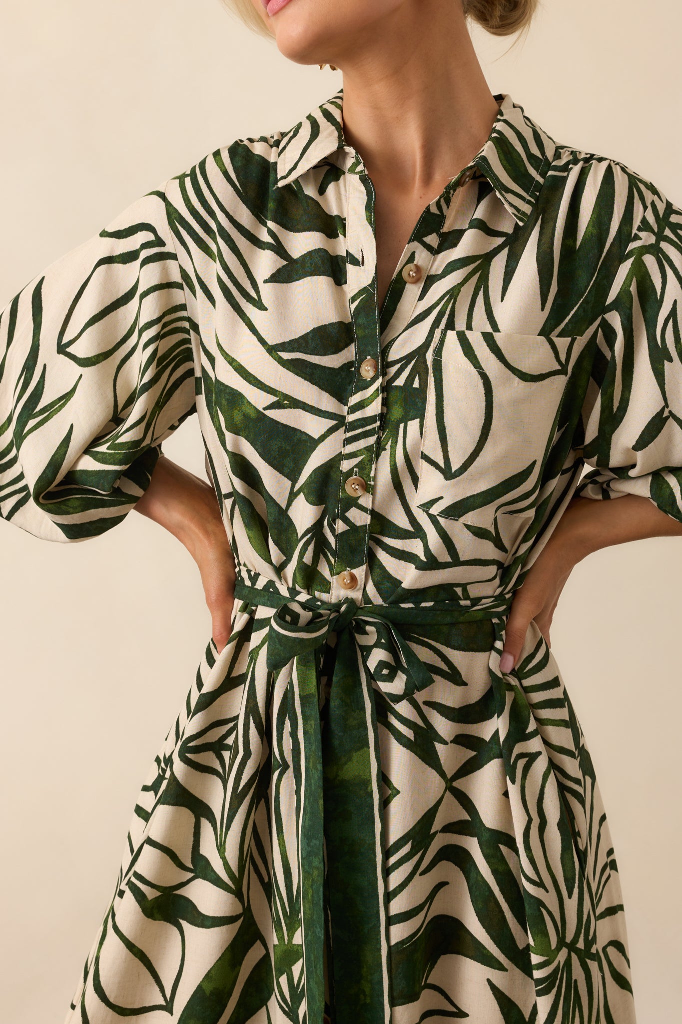 Close-up of the breast pocket and button placket, highlighting the green and beige tropical print and texture of the fabric.