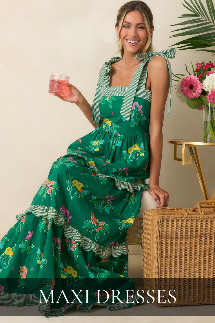 Model wearing a green floral tiered maxi dress with bow tie straps featured in the Red Dress Maxi Dresses collection.