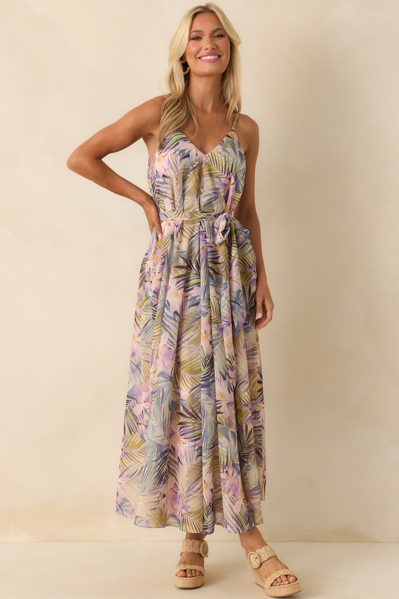 A full-length shot showcasing the deep v-neckline, center box pleat detailing, and flowy silhouette of the tropical print dress.