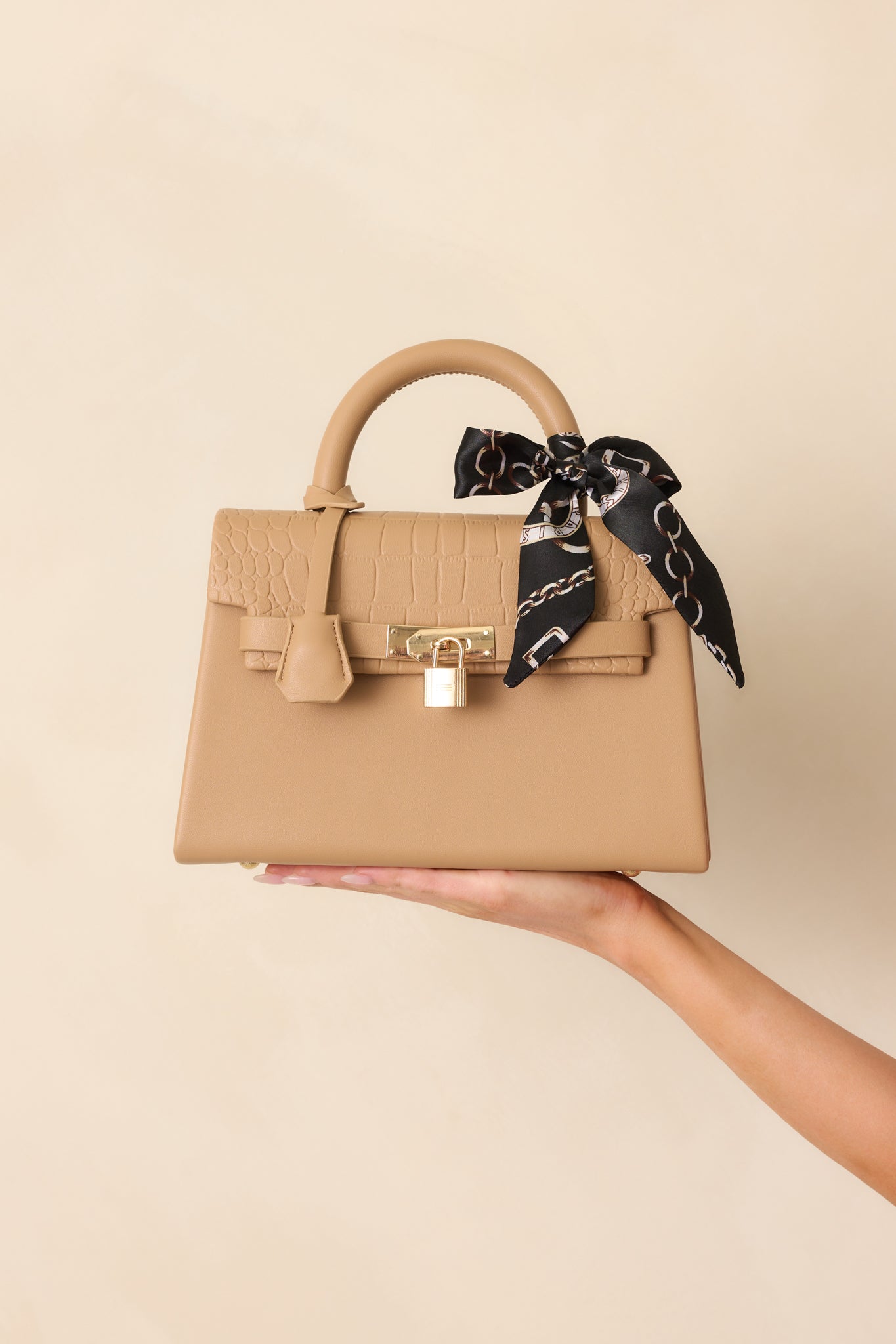 Front-facing image highlighting the magnetic flap closure and included adjustable crossbody strap attached.