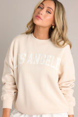 Angled front view of this natural embroidered sweatshirt that features 